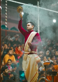 a man in a red and white outfit holding a candle