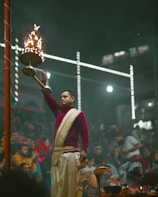 a man in a red and white outfit holding a basket of fire