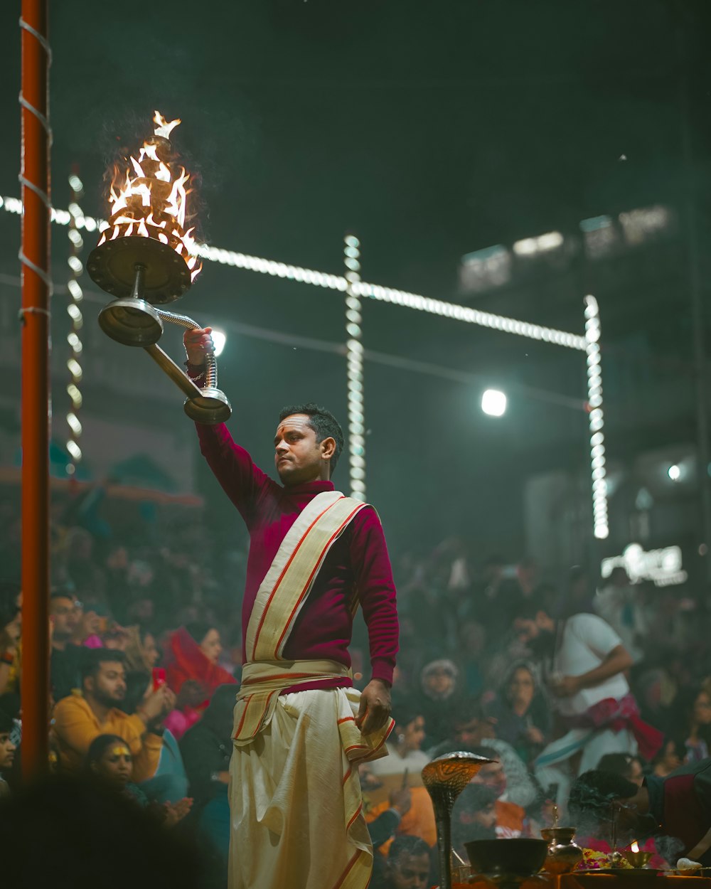 a man in a red and white outfit holding a basket of fire