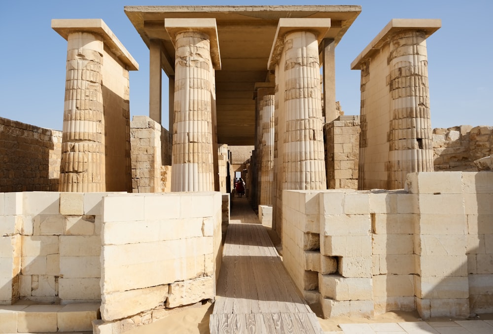 a group of pillars in a building with a sky background