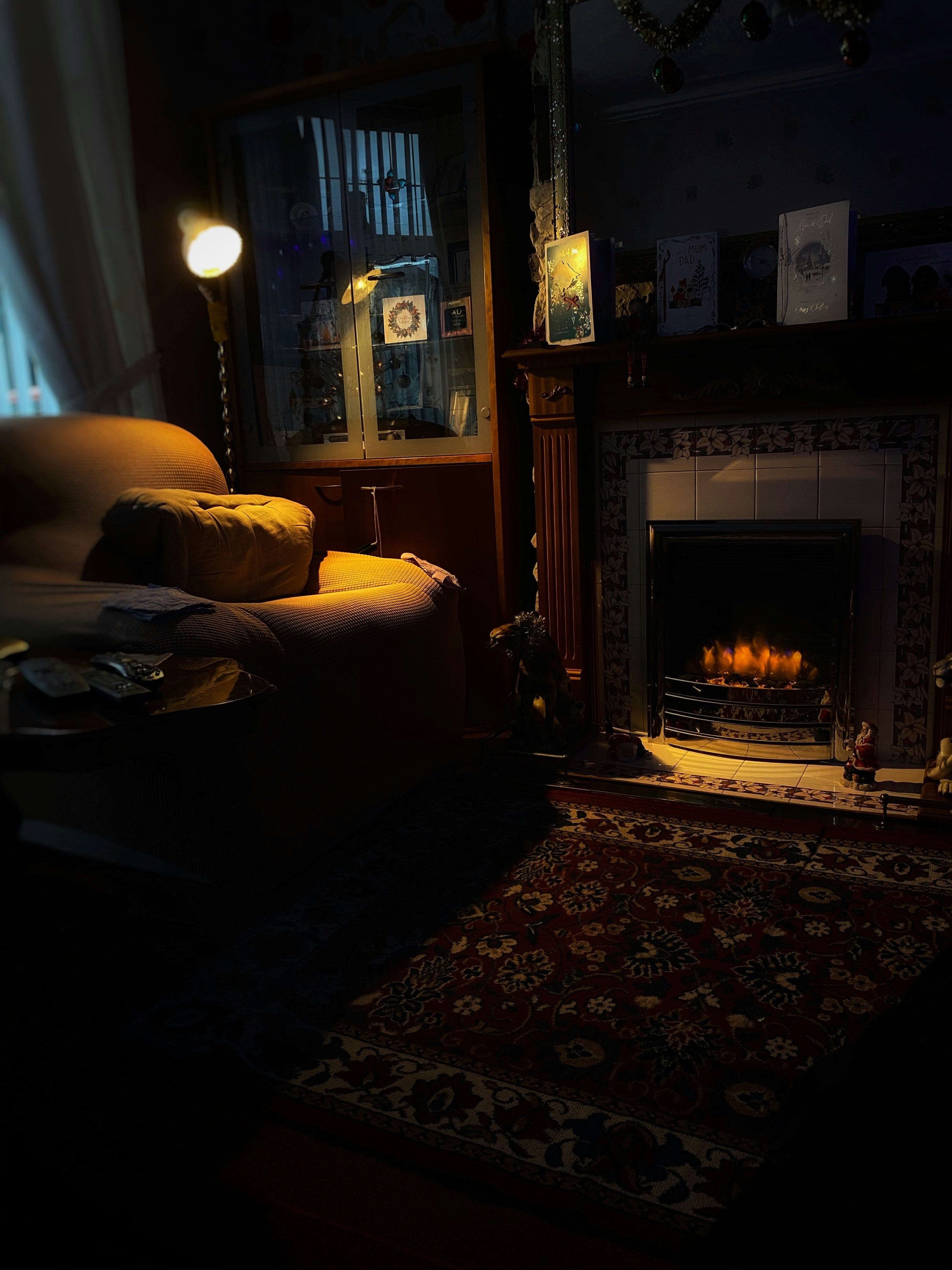 Cozy residential living room with warm lighting, comfortable furniture, dim atmospheric setting, dark tones, shadowy interior