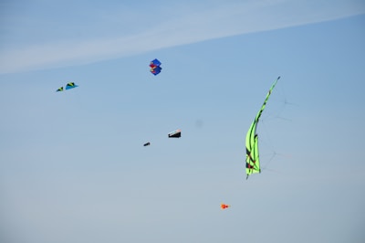 A close-up of colorful kites soaring against a clear blue sky.