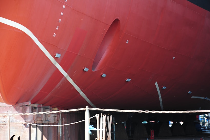 a large red boat sitting in a dry dock