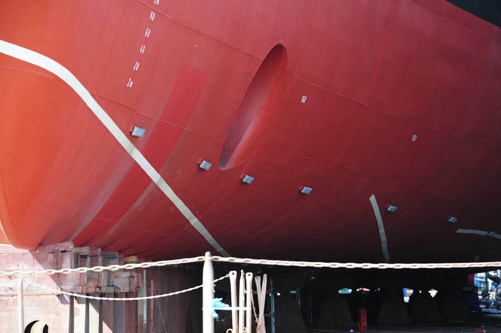 a large red boat sitting in a dry dock