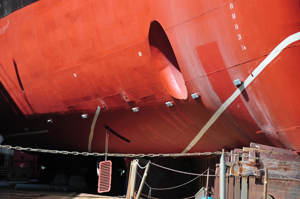 a large red boat sitting in a dry dock