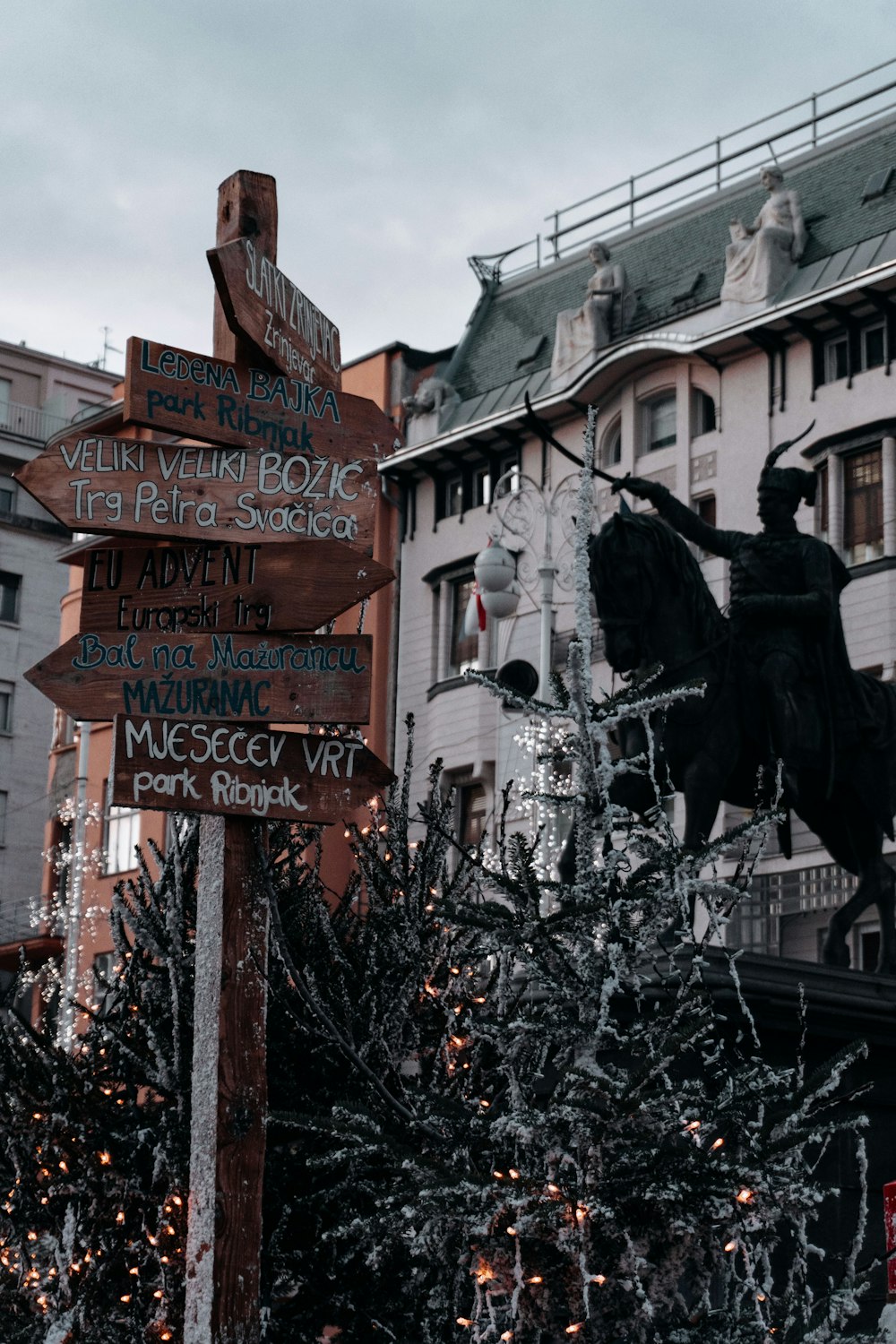 a statue of a man riding a horse next to a street sign