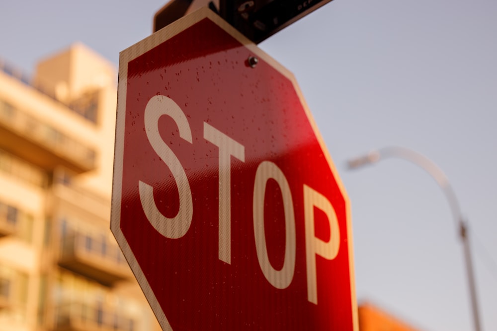 a close up of a stop sign with a building in the background