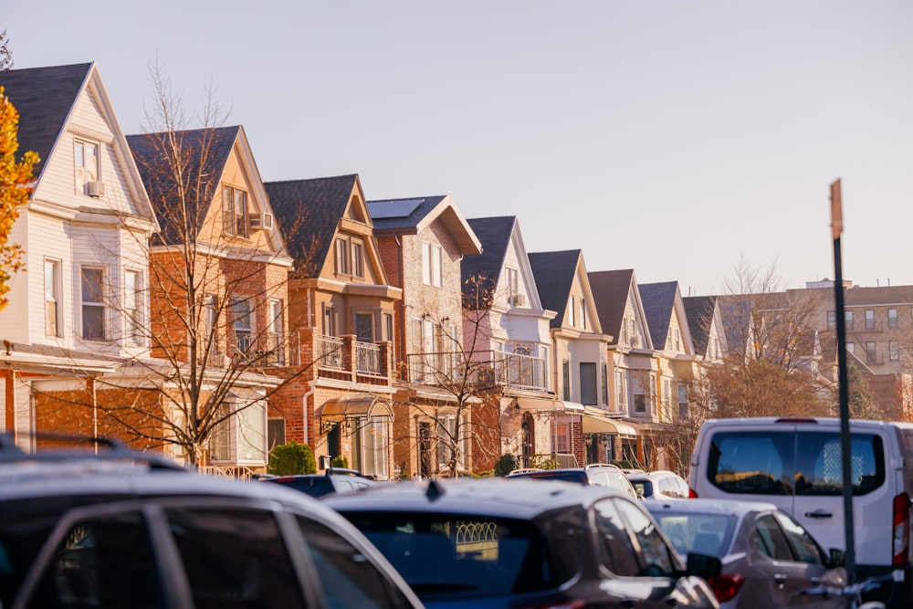 a row of houses with cars parked in front of them