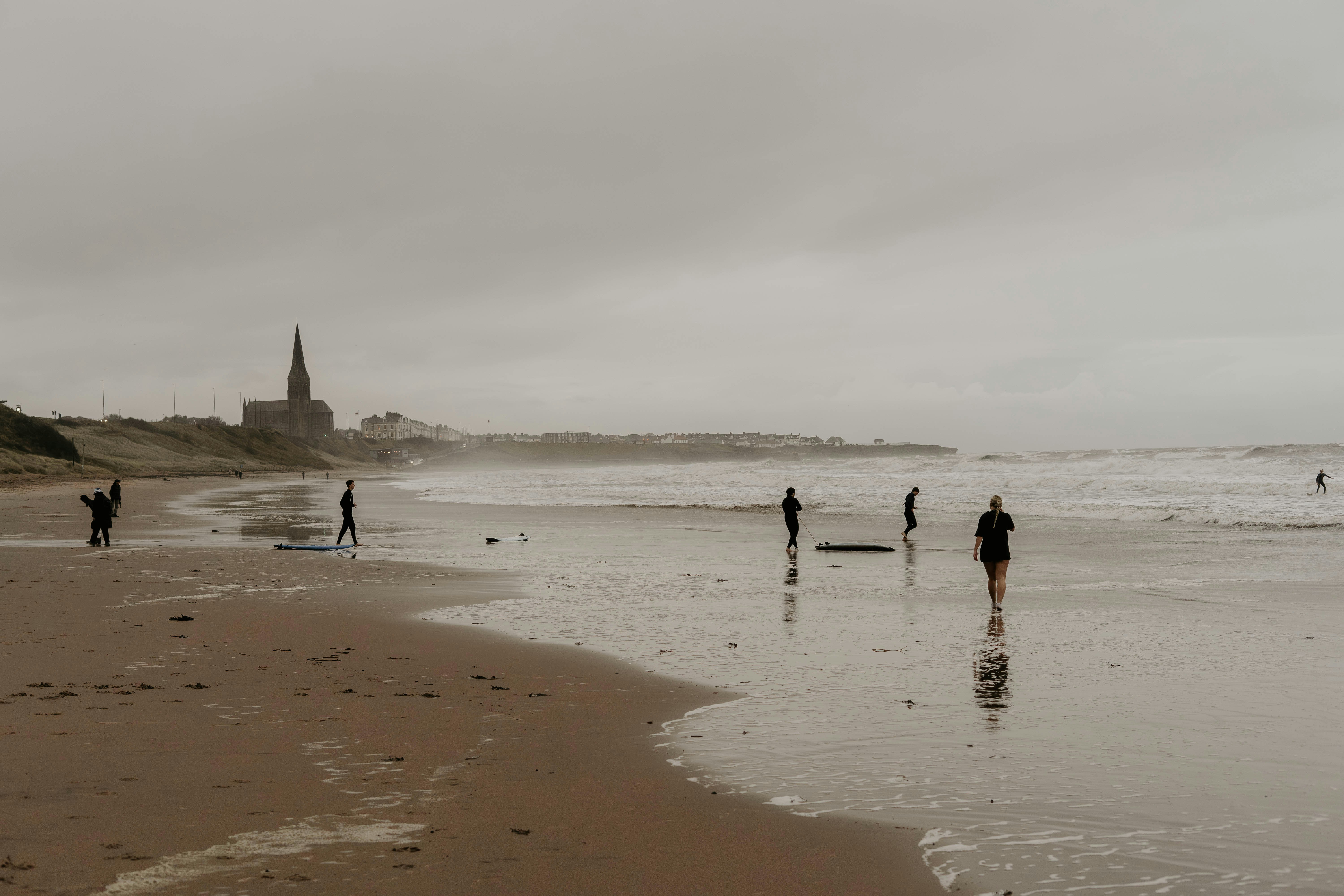 a group of people standing on top of a sandy beach