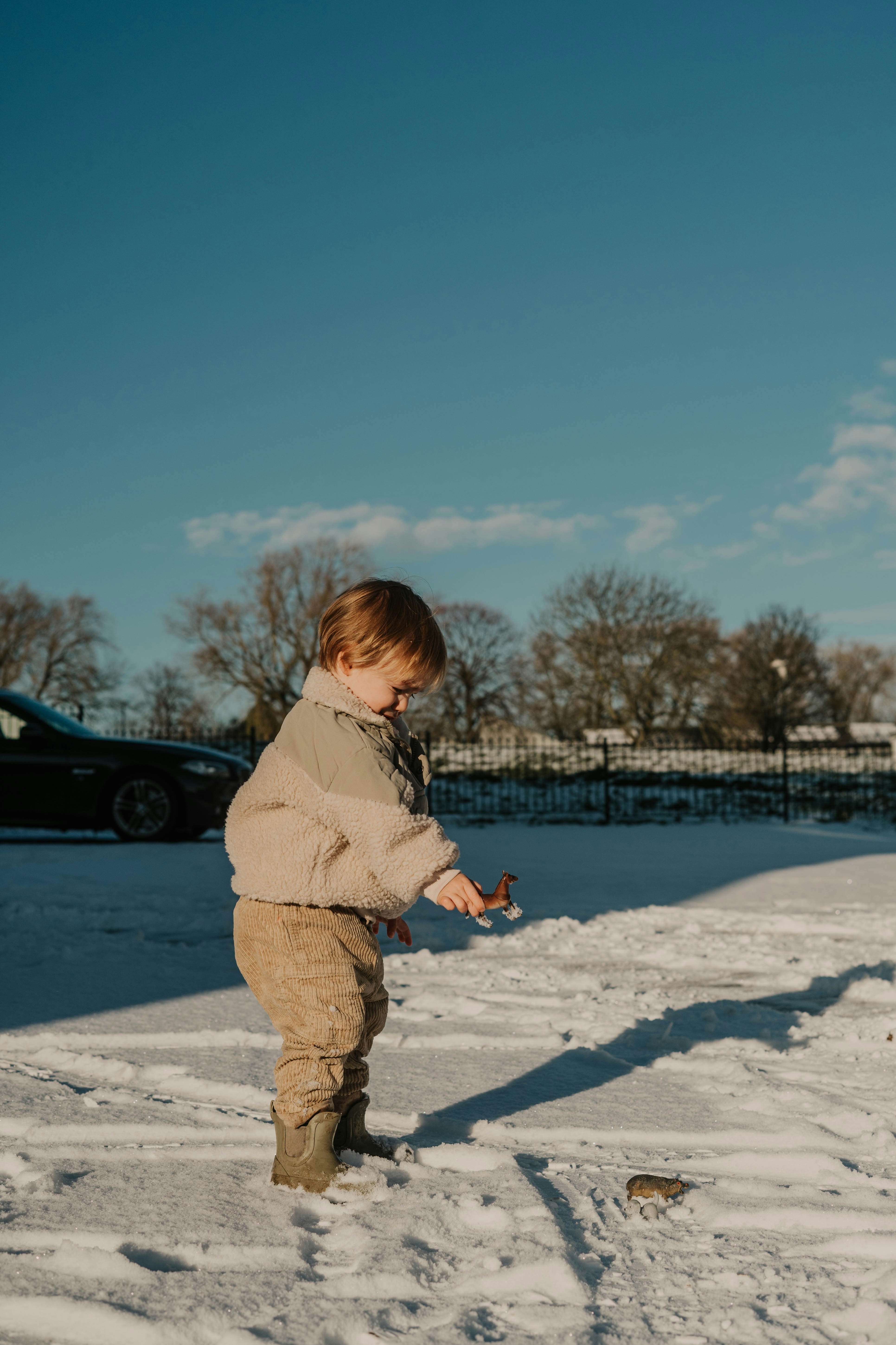 a little boy playing in the snow with a frisbee