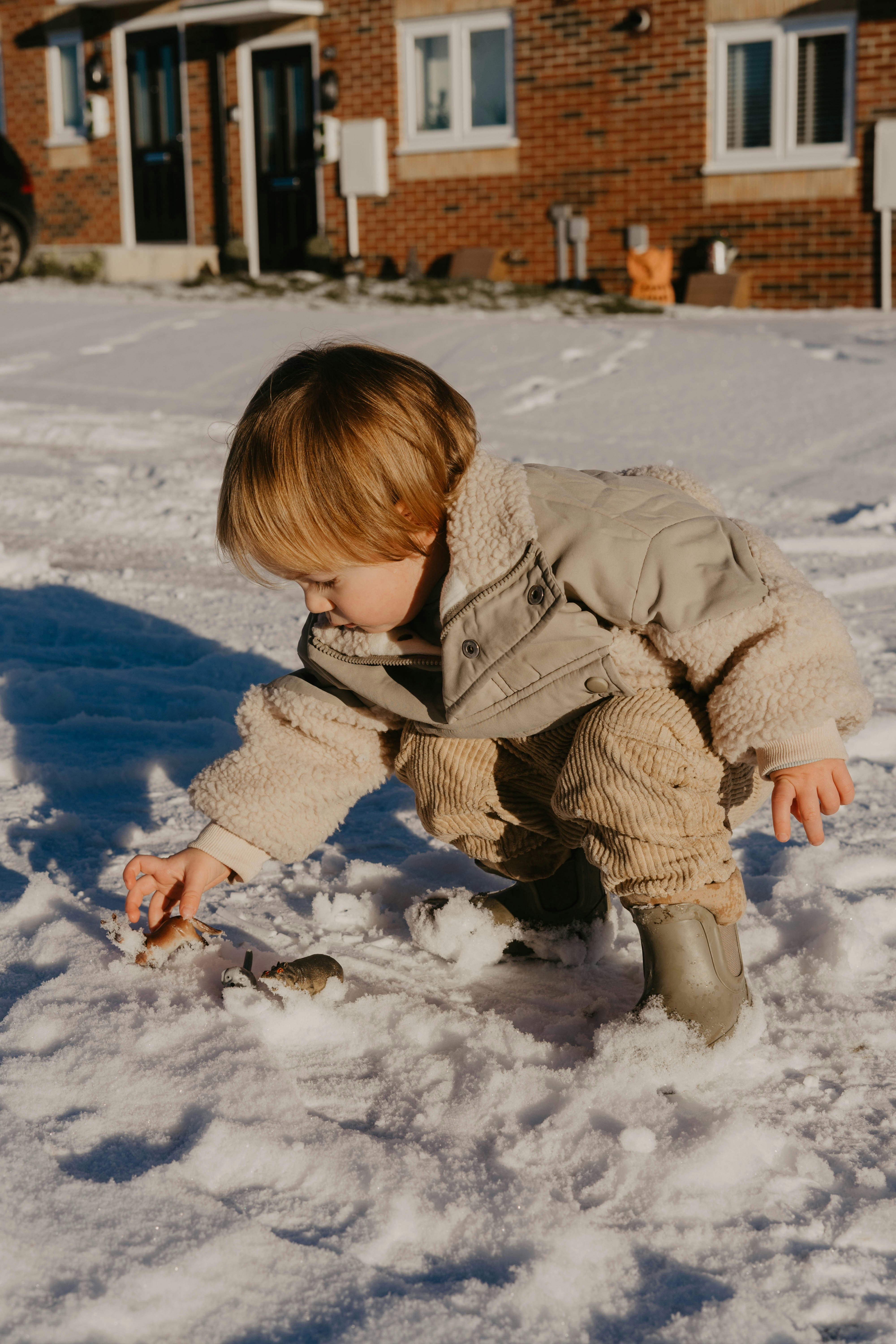 a little boy playing in the snow outside