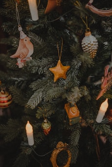 Delicate wooden Christmas decorations hanging on a festive tree with warm lights