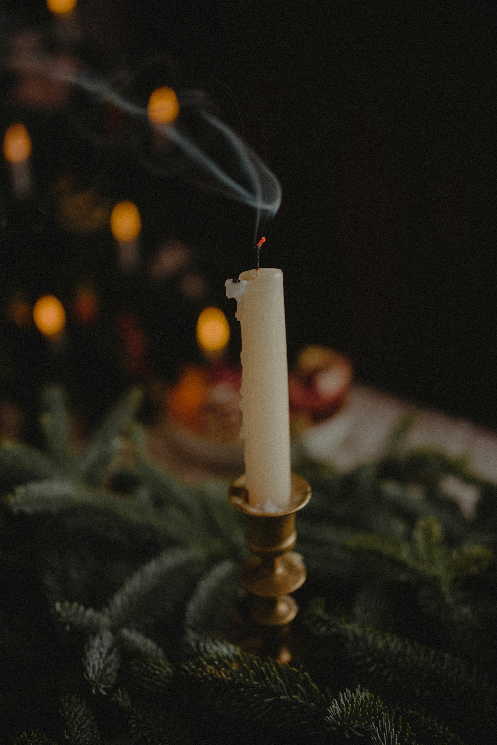 a lit candle sitting on top of a christmas tree