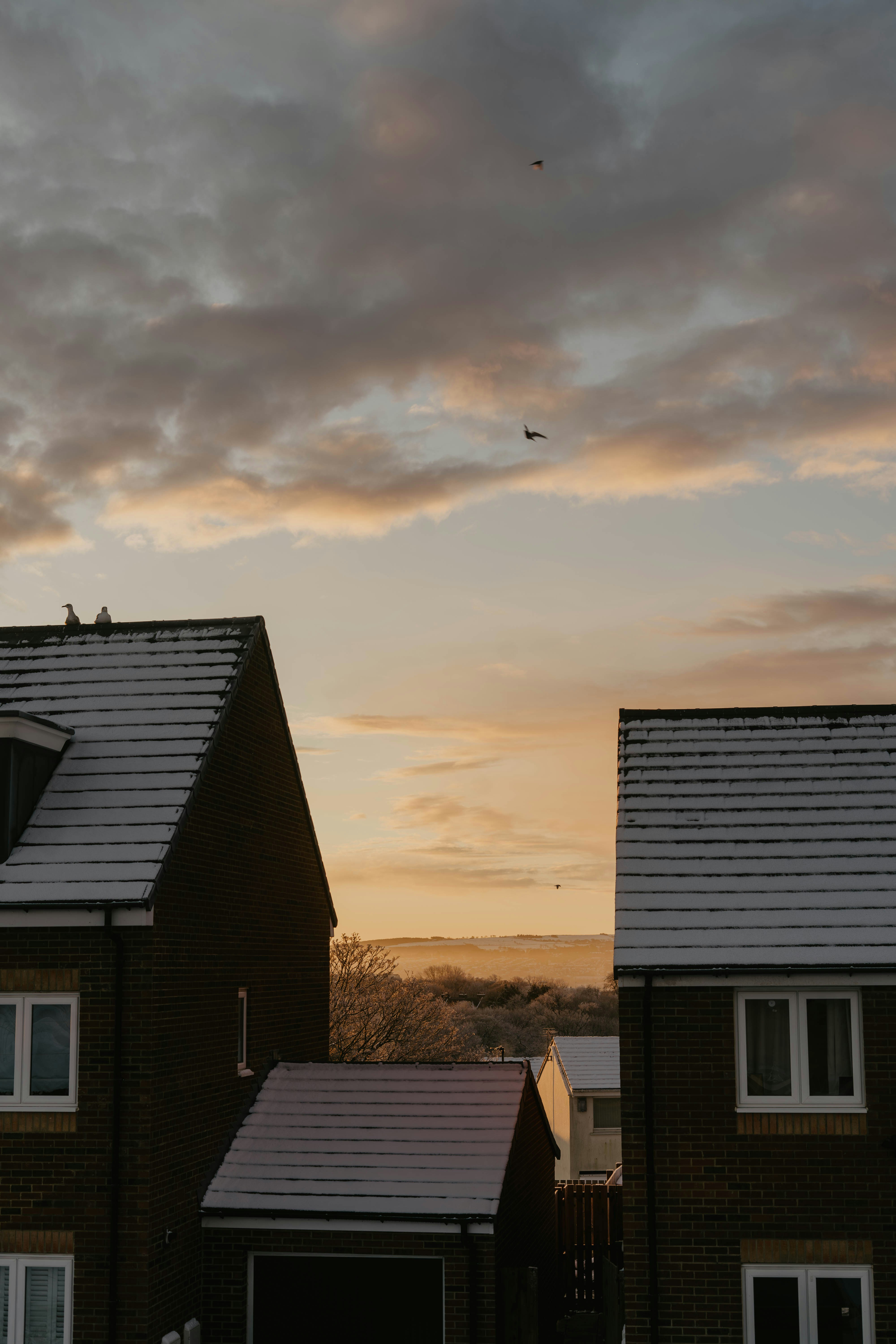 a couple of houses sitting next to each other under a cloudy sky