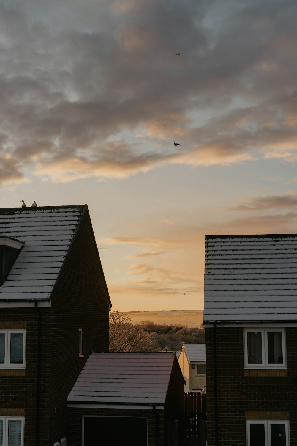 a couple of houses sitting next to each other under a cloudy sky