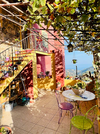 Cozy terrace at Maison Marly with rustic wooden furniture and blooming flowers.