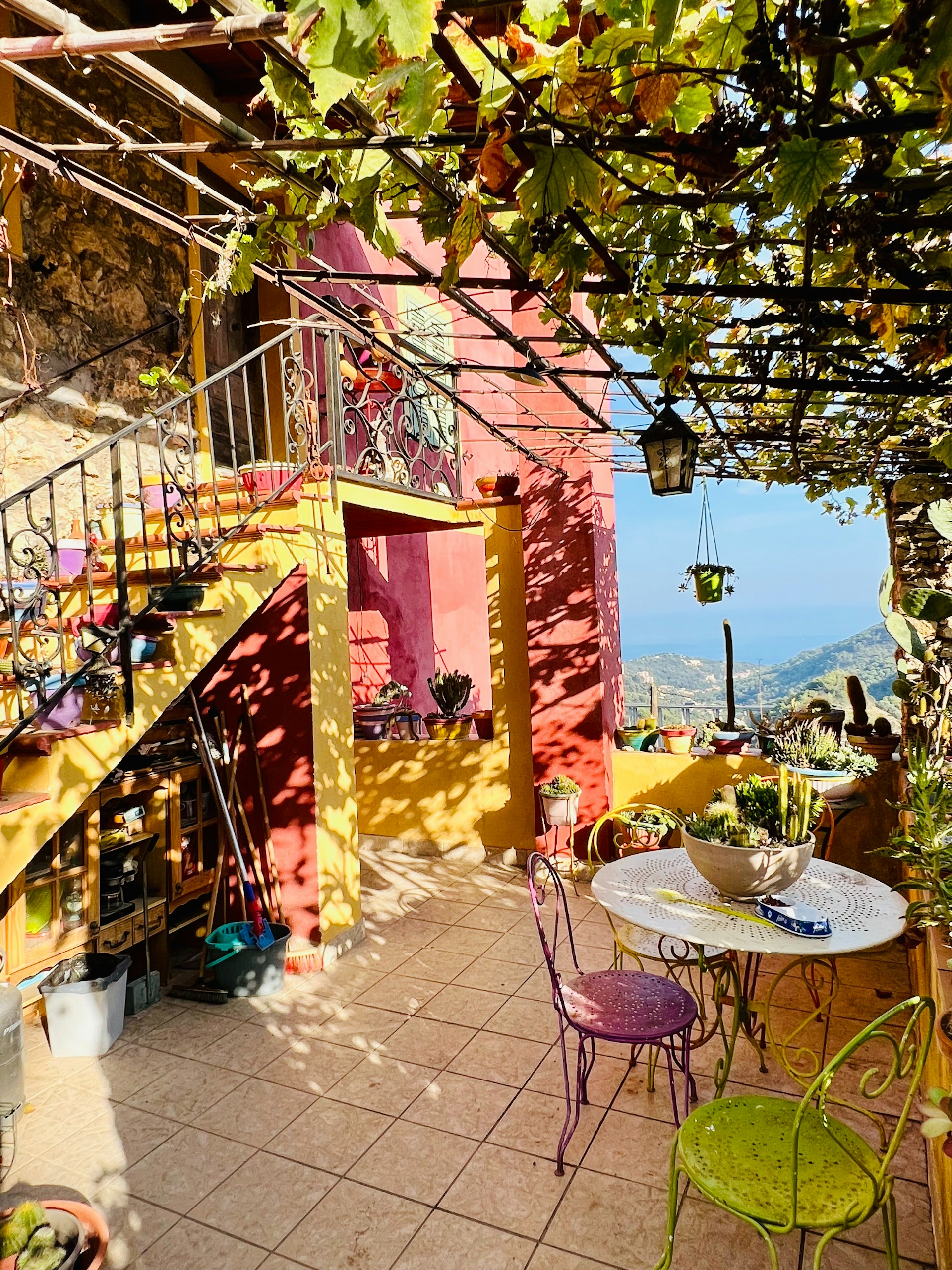 Colorful garden terrace of the Chabaillac gîte, adorned with bright flowers and rustic wooden furniture inviting guests to relax outdoors.