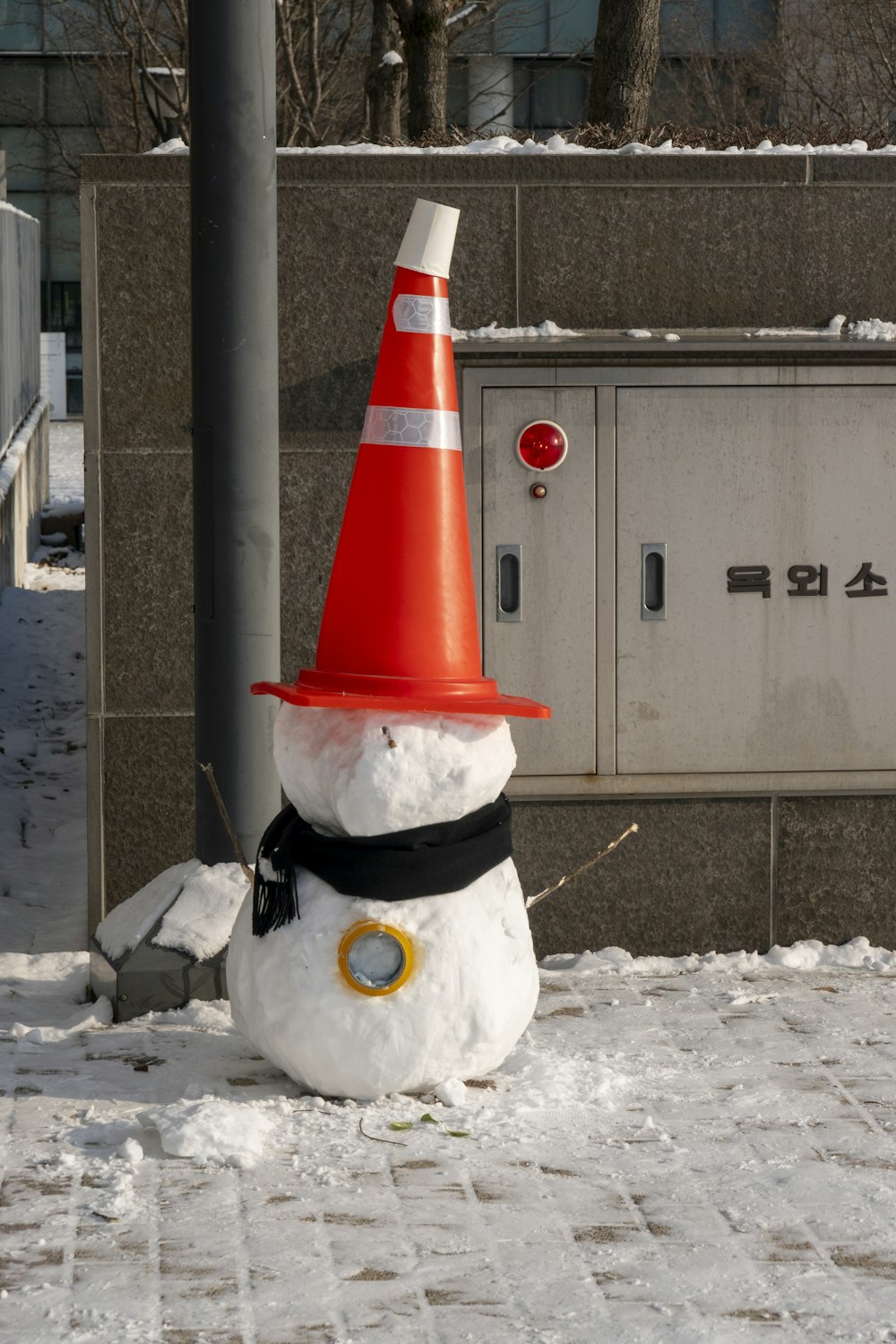 a snowman with a traffic cone on his head