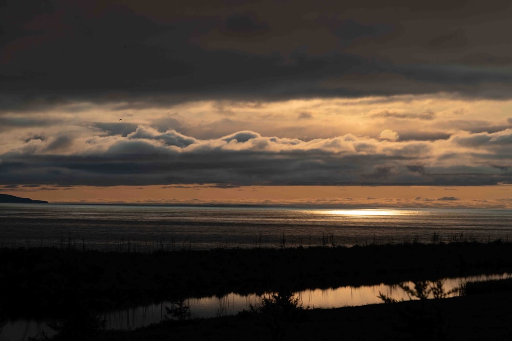 the sun is setting over a body of water