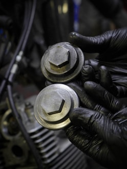 a close up of a person wearing black gloves holding a metal object