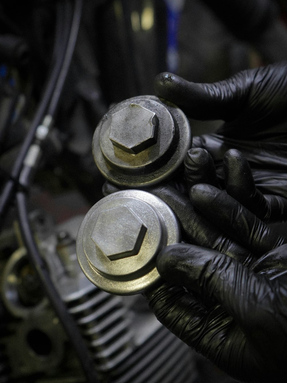 a close up of a person wearing black gloves holding a metal object