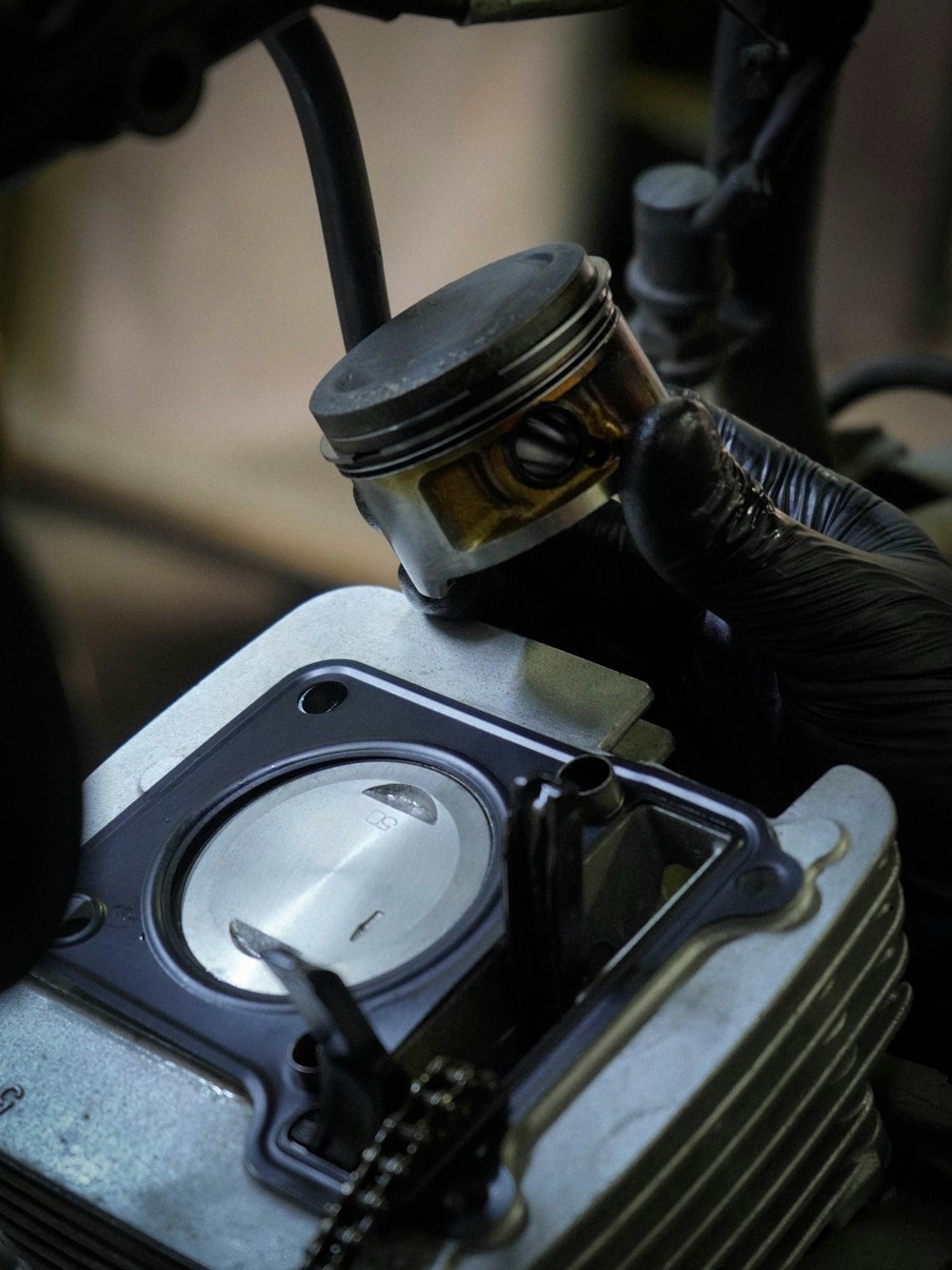 a close up of a motorcycle engine with a person wearing gloves