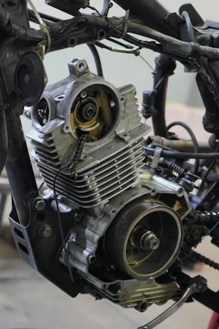 Display of various motorcycle transmission parts organized neatly on a workbench.