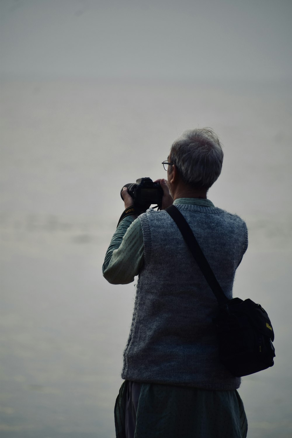 a man taking a picture of a body of water