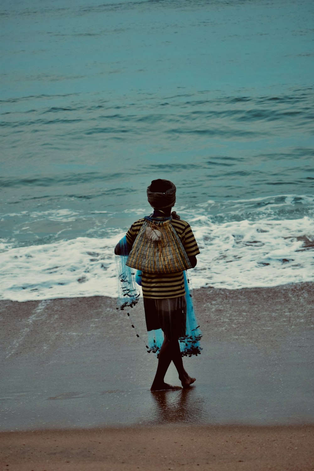 a person walking on a beach near the ocean