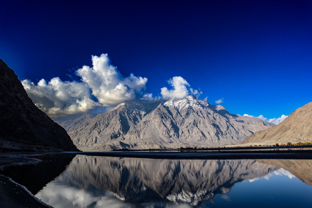 the mountains are reflected in the still water of the lake