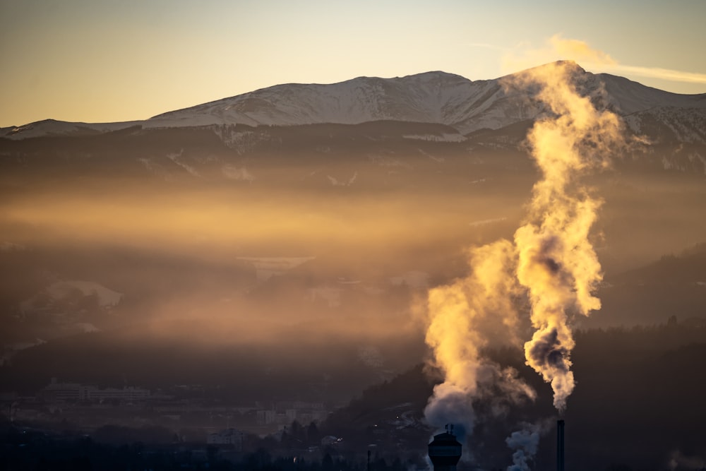 a smokestack emits from the top of a mountain