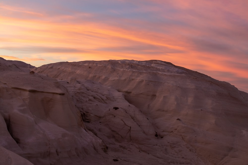 the sun is setting over the mountains in the desert