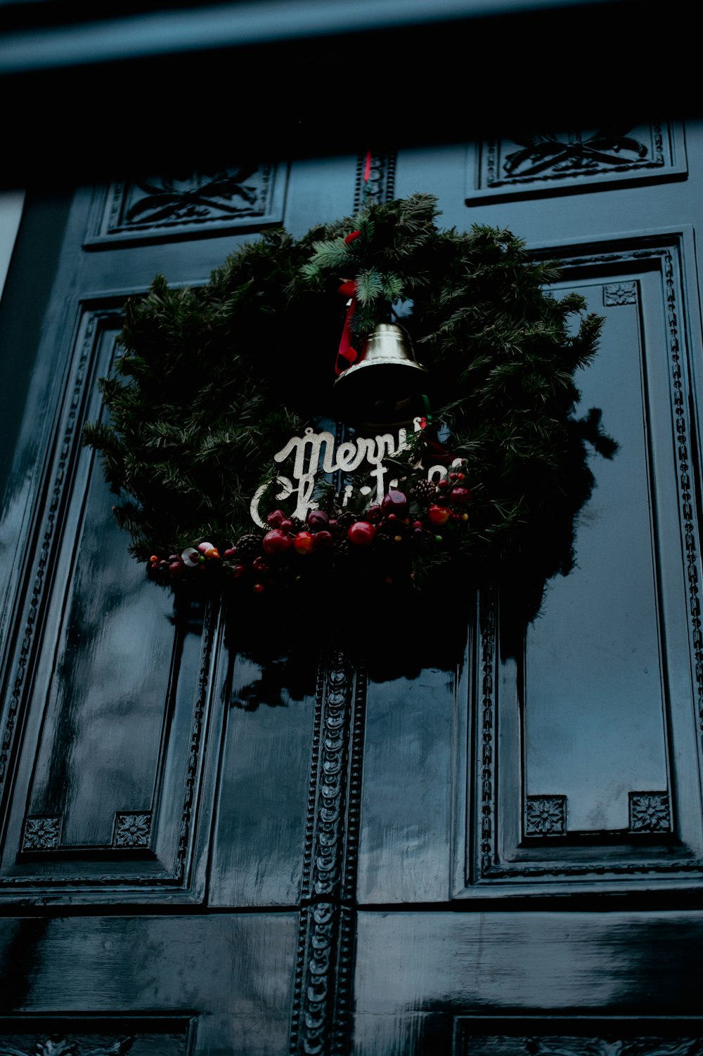 a christmas wreath hanging on the front door of a building