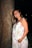 a pregnant woman standing next to a tree