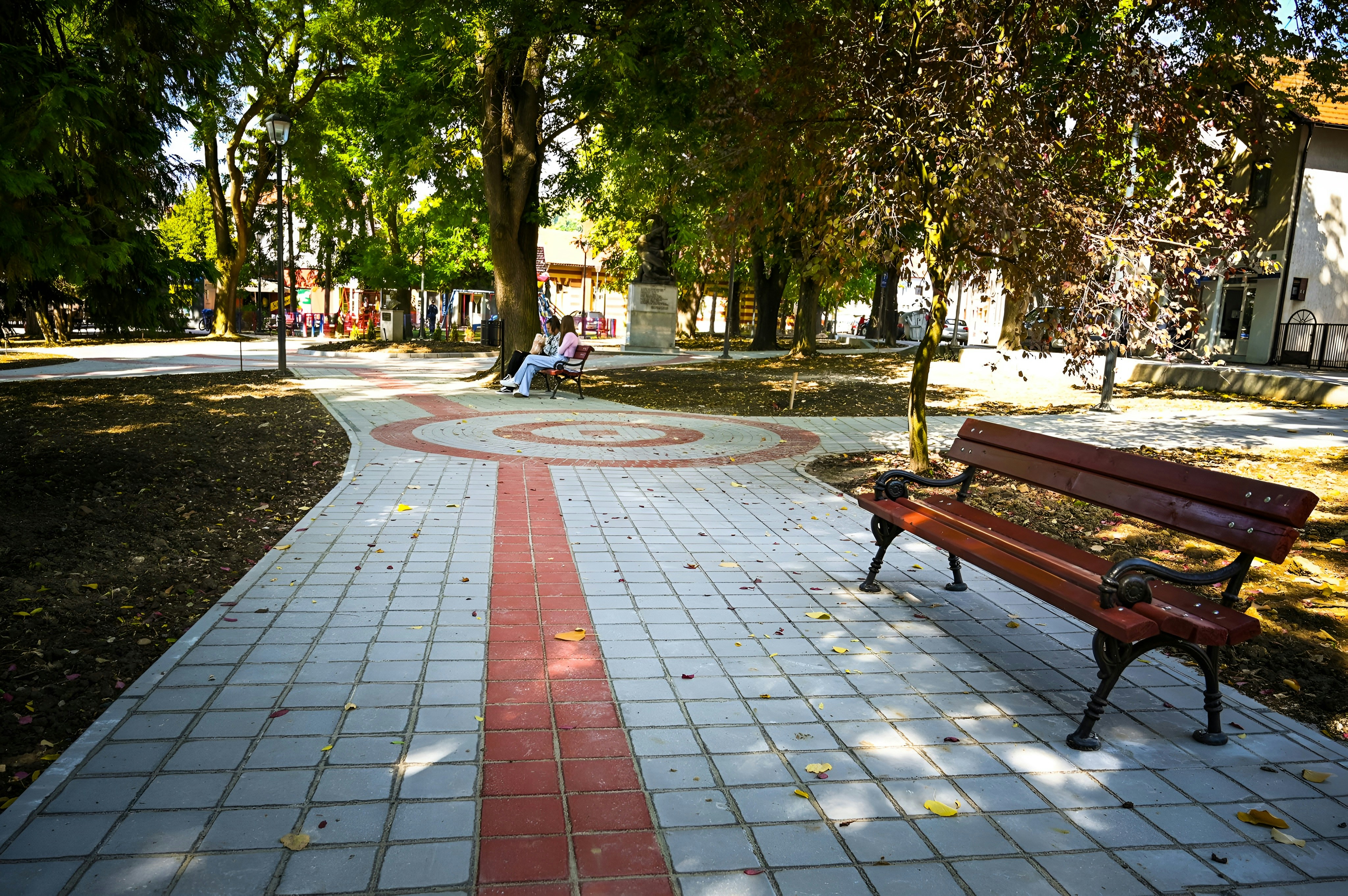 a park bench sitting on top of a sidewalk