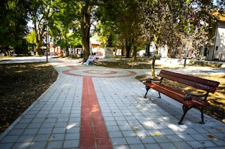 a park bench sitting on top of a sidewalk