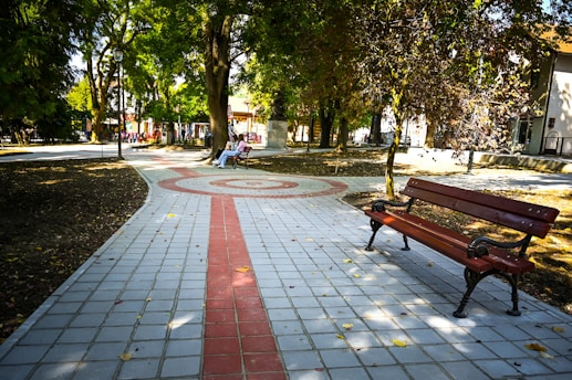 a park bench sitting on top of a sidewalk
