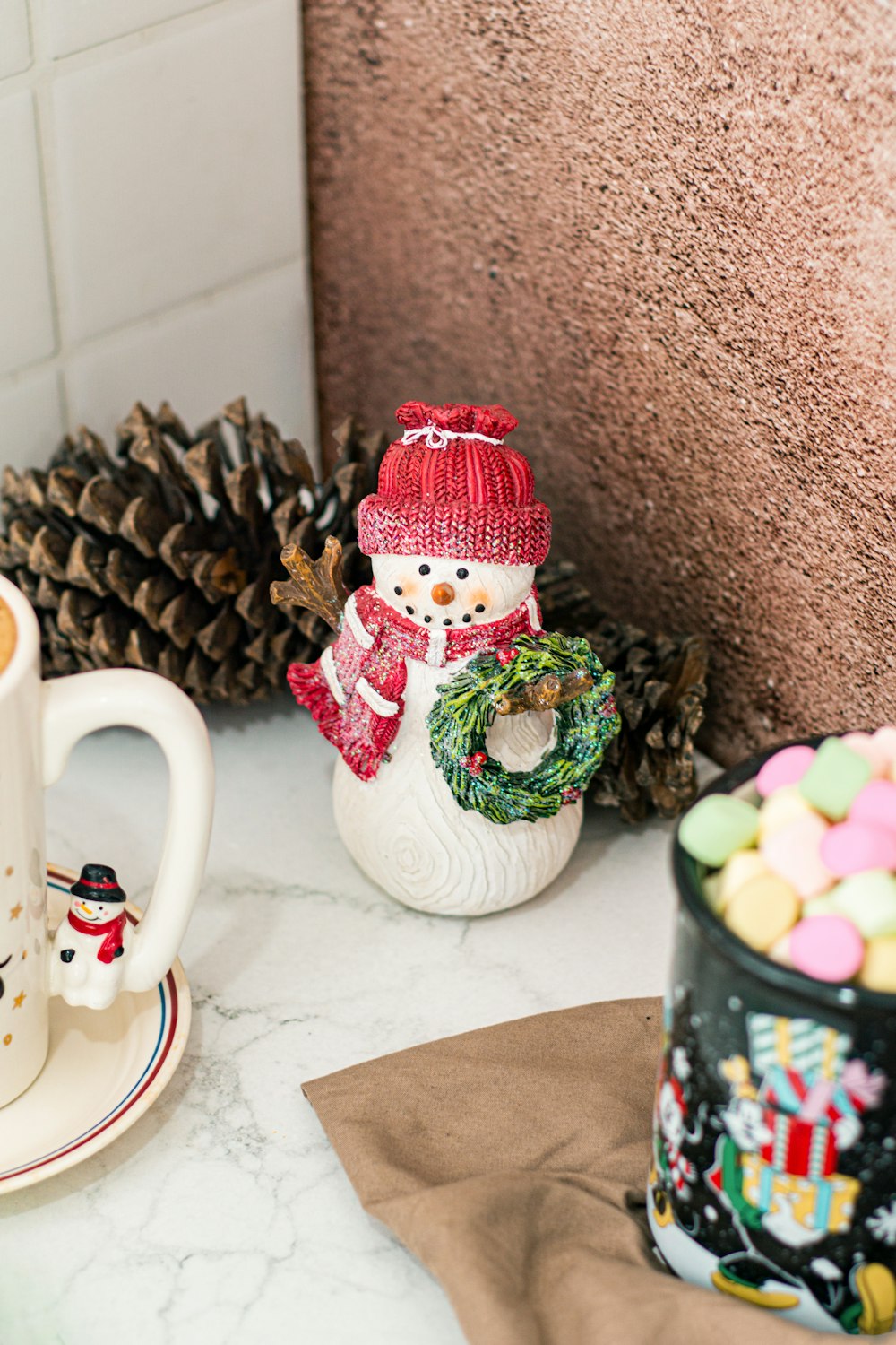 a snowman figurine sitting next to a cup of coffee