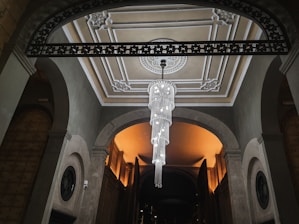 Close-up of a grand chandelier glowing elegantly against a royal blue and white themed interior.