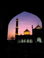 Evening sky behind Shah Jalal Masjid with softly glowing lights.