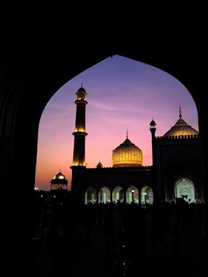 Evening sky behind Shah Jalal Masjid with softly glowing lights.