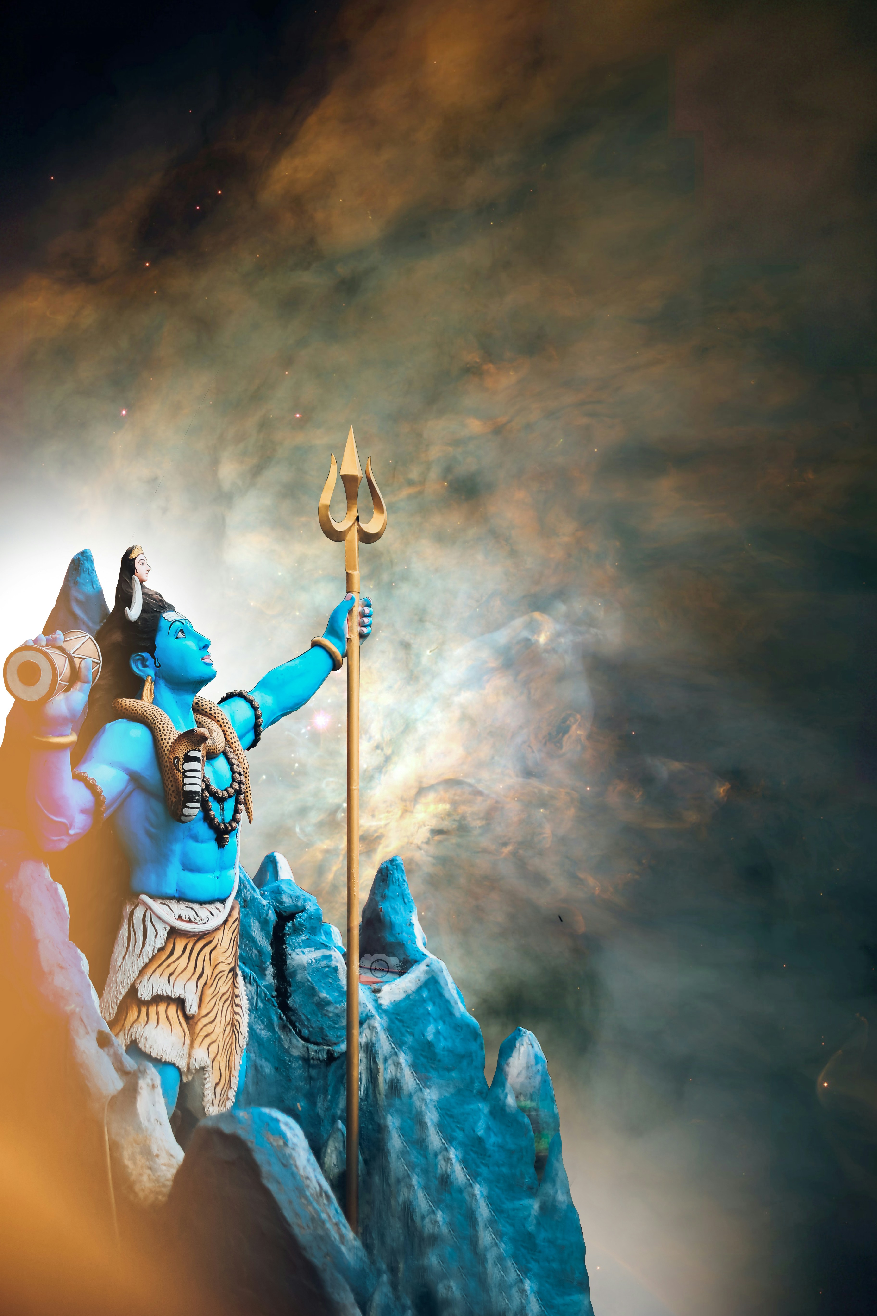 a statue of a man holding a spear on top of a mountain