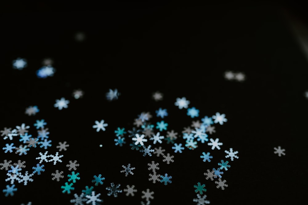 a bunch of snow flakes on a black surface