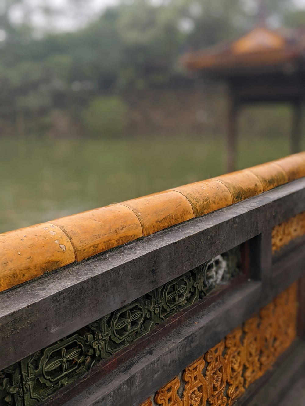 a close up of a wooden fence with a building in the background