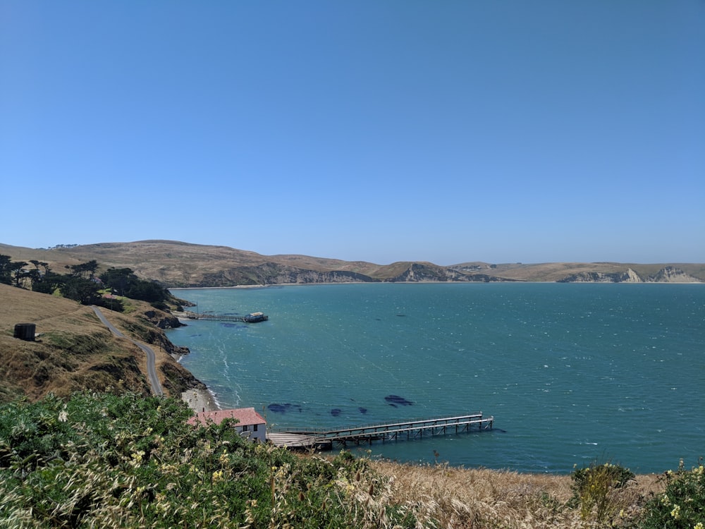 a large body of water surrounded by a lush green hillside