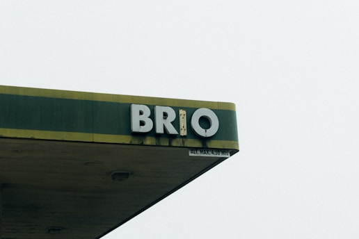 A section of a building with the letters 'BRIO' mounted on its side. The structure is topped with a green and yellow awning and there is a sign indicating a maximum height of 4.50 meters.