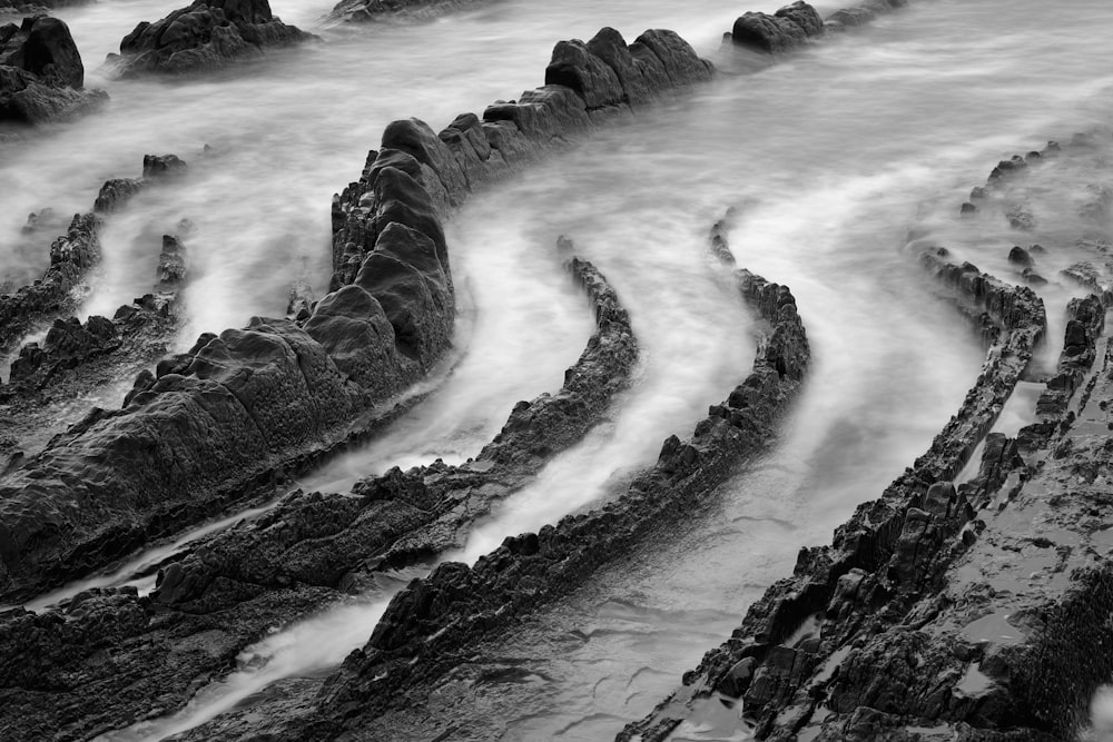 a black and white photo of rocks and water