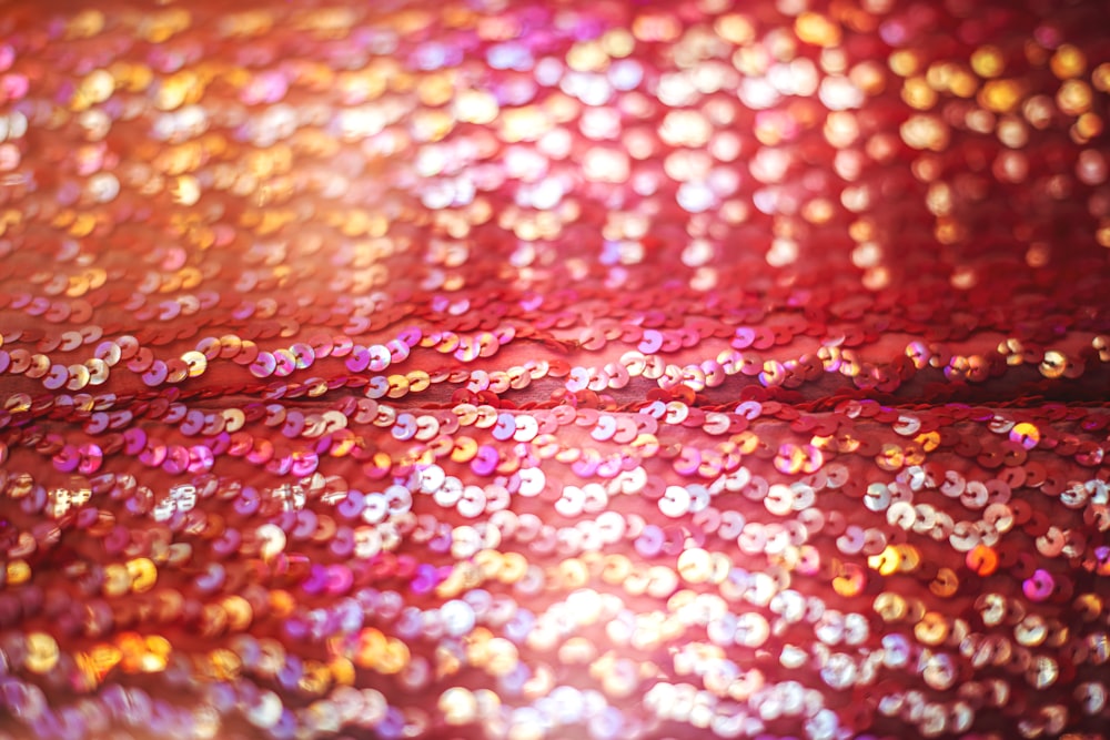 a close up of a red and gold sequin fabric