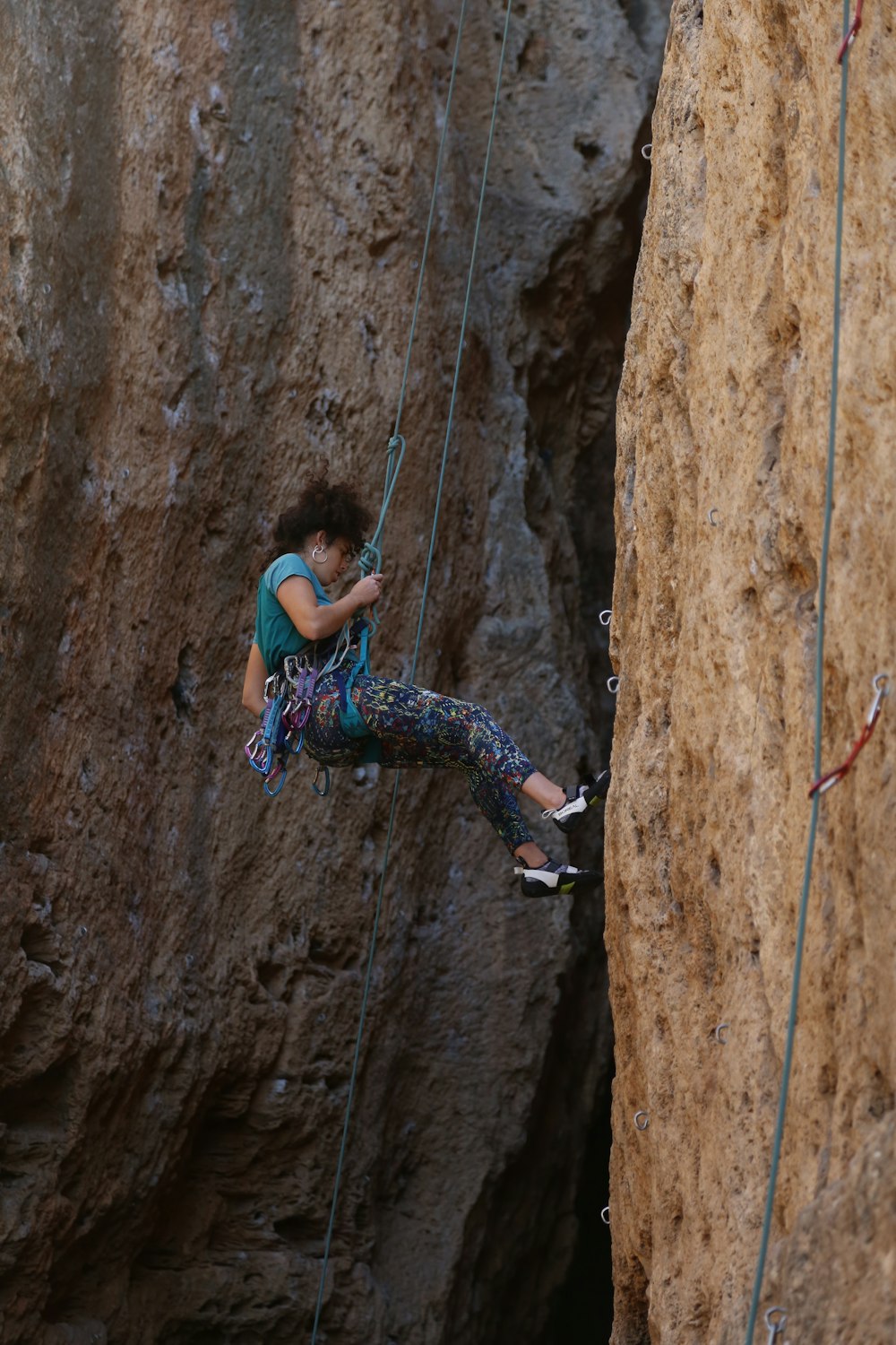 a man climbing up a cliff with a cell phone in his hand