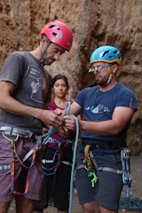 Team installing safety harnesses before climbing.